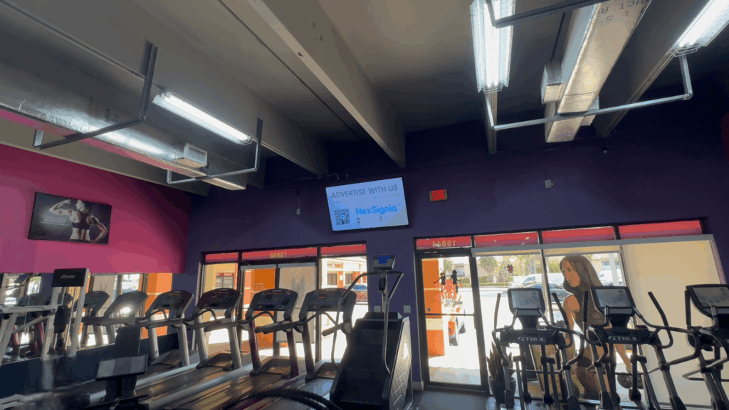 Digital signage monitor displaying local ads in a fitness center