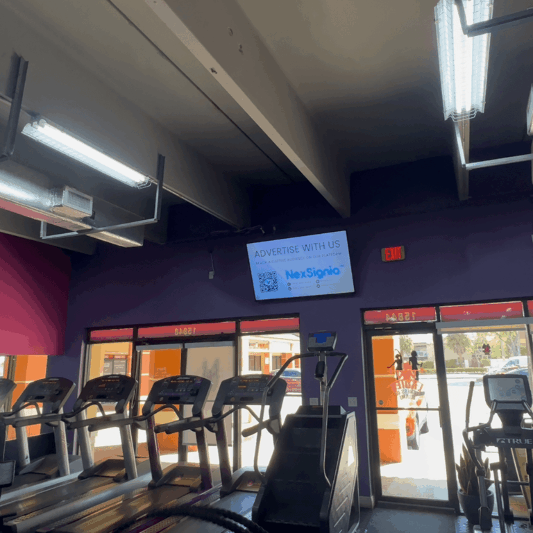 Digital signage monitor displaying local ads in a fitness center